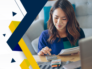 Woman of Asian descent using a calculator at a desk