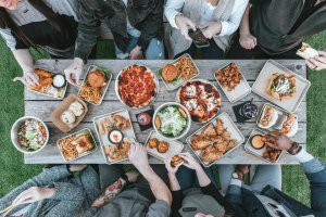 Long picnic table of people with german food