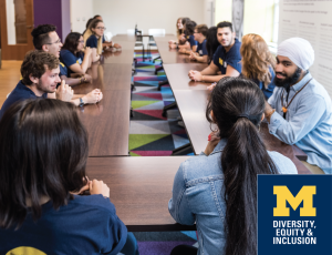 A diverse group of people sitting at a rectangular table having a conversation