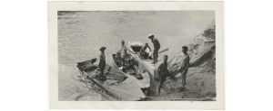 An old black and white photo showing Elzada Clover and crew in boats the edge of a river