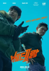 A promotional poster for the Korean action crime film 'I, The Executioner,' featuring two male characters looking down from a low-angle perspective. The character on the left wears a green jacket with a fur-lined hood and gloves, sporting a confident smirk, while the character on the right, in a dark jacket, has a stern expression with his hands on his hips. A promotional poster for the Korean action crime film 'I, The Executioner,' featuring two male characters looking down from a low-angle perspective. The character on the left wears a green jacket with a fur-lined hood and gloves, sporting a confident smirk, while the character on the right, in a dark jacket, has a stern expression with his hands on his hips.