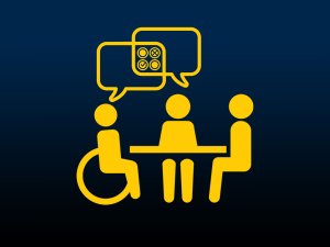 3 people seated at a table, one is a wheelchair user, with an overlapping speech bubble showing circles with checks and x's.