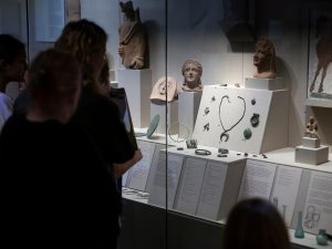 Visitors at the Kelsey Museum view objects relating to health and beauty in Roman, including votive figures, amulets, and jewelry.