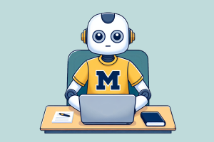 Gender nondescript robot wearing a maize shirt with a blue block M sits behind a laptop at a desk