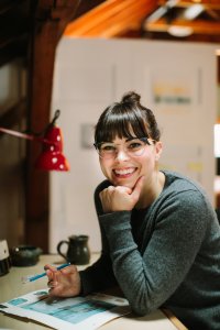 Woman posed with pencil in hand working on an illustration