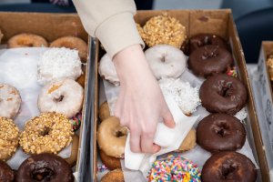 Student reaching for donut