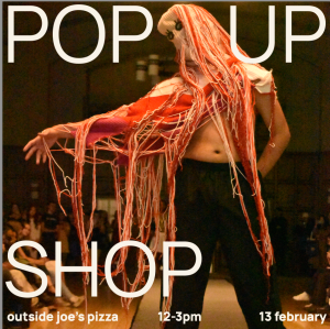 Image with white text listing "POP-UP SHOP. outside of joe's pizza. 12-3p. 13 february" Background image is a sweater with a hoodie and many pink strings Image with white text listing "POP-UP SHOP. outside of joe's pizza. 12-3p. 13 february" Background image is a sweater with a hoodie and many pink strings