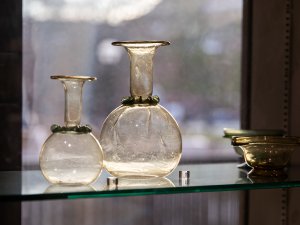 Display of glass objects at the Kelsey Museum. At the left are two vessels with rounded bellies, skinny necks, and wide spouts, while at the right are two low bowls. Display of glass objects at the Kelsey Museum. At the left are two vessels with rounded bellies, skinny necks, and wide spouts, while at the right are two low bowls.