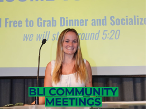 Picture of a blonde woman at a podium, smiling. Text "Community Meetings" at the bottom in navy with a green block background. Picture of a blonde woman at a podium, smiling. Text "Community Meetings" at the bottom in navy with a green block background.