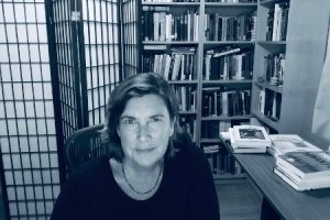 Black and white photo of Virginia Jackson in front of bookshelf