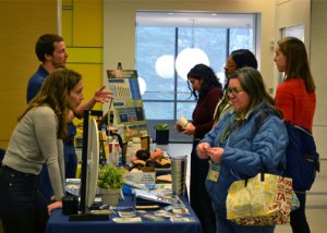 Sustainability staff interacting with researchers at an informational table