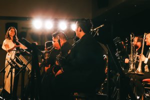 Julia Keefe conducting band with large lights in background