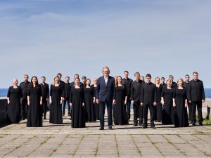 Choir in all black clothes against blue sky