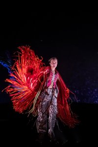 A woman performs wearing a red costume.