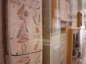 Close-up of a stone false door panel on display in the Kelsey Museum. Its surface is carved with hieroglyphs painted with red, yellow, green, and blue.
