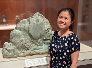 Headshot of Yulian Wu. She has her dark hair pulled back and is wearing a floral shirt. She is standing in front of an ornate jade sculpture. Headshot of Yulian Wu. She has her dark hair pulled back and is wearing a floral shirt. She is standing in front of an ornate jade sculpture.
