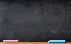 a picture of a blank chalk board with red and blue pieces of chalk waiting to be used