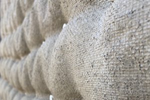 Fabric-formed poured earth: a section of a textured wall structure in an ecru color. Fabric-formed poured earth: a section of a textured wall structure in an ecru color.