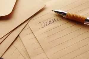 letter with a pen and "Dear" writen on the paper letter with a pen and "Dear" writen on the paper
