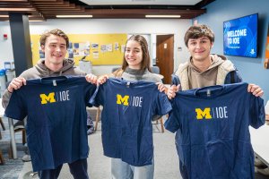 Three people hold up an Industrial and Operations Engineering t-shirt. Three people hold up an Industrial and Operations Engineering t-shirt.