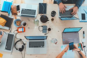 Overhead view of people working on laptops together