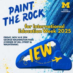 Graphic promoting “Paint the Rock for International Education Week 2025.” The background features blue paint splashes and a large illustration of the U-M Rock painted blue with “IEW” in yellow letters and a yellow airplane flying across it with a dotted path. Event details: Friday, Nov 14 at 3 PM, George Washington Park (corner of Hill Street and Washtenaw). University of Michigan Global Engagement logo in the upper right corner.