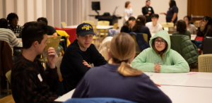 Four students have a conversation around a table
