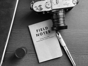 A photo camera and a notebook