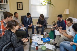 Group of people sitting around a coffee table engaged in conversation