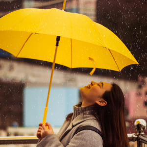 Person standing under an umbrella smiling