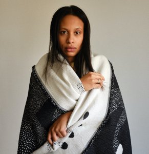 A portrait image of the speaker wrapped in a scarf.