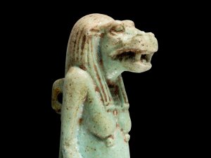 Faience figurine of the Egyptian goddess Taweret, who has the face of a hippopotamus with long hair.