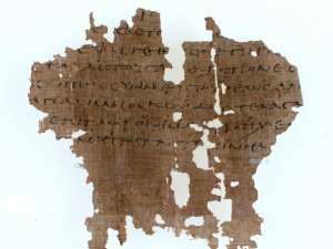 Irregularly shaped fragment of tan papyrus with Greek writing.