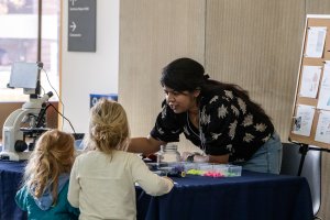 EEB postdoc Anjali Mahilkar explaining pizza yeast evolution to young visitors