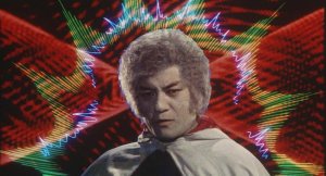 A film still of a Japanese man in dramatic clothing with colorful, abstract graphics in the background