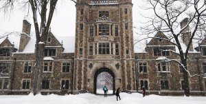 Law Quad in winter with people walking, falling snow, snow-covered sidewalks