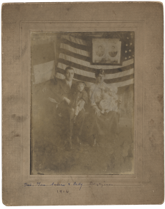Kharpertzis (those with Kharpert ancestry) Sarkis and Mary Kazanjian Boyajian with their children, Andrew and Elizabeth, at home in front of a wall decorated with the United States flag and photographs of Sarkis’ parents, Gabriel and Elizabeth Boyajian.