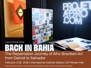 A promotional banner for the LACS exhibition titled "BACK IN BAHIA: The Repatriation Journey of Afro-Brazilian Art from Detroit to Salvador." The background shows an indoor gallery space featuring a neon sign for "PROJETOAFRO.COM," a collage of small artworks on a black pillar, and open books on a display table. In the background, a red flag with a black and white circular emblem is visible. The exhibition runs from February 2–26, 2026, at the International Institute Gallery, 547 Weiser Hall. Presented by the Center for Latin American and Caribbean Studies and the Institute for the Humanities.