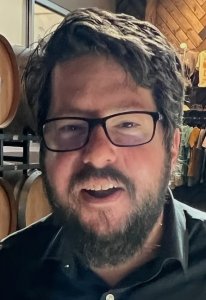 Man with beard and glasses in black shirt