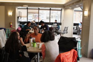 Students at tables eating and socializing at CEW+ Study Day