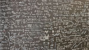 Math written in chalk on a chalk board.