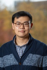 Headshot of individual with glasses and blue sweater