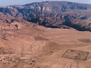 Overview of the archaeological site of Humayma, an ancient settlement in Jordan, with mountains rising in the background.