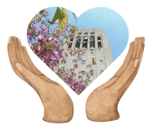 Two hands craddling a heart shaped photo of pink flowers in front of a tower.