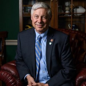 Fred Upton wearing a dark blue jacket, light blue shirt, blue and gray striped tie