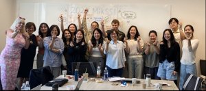 A group of people stand in front of a whiteboard, written on the whiteboard is the phrase 2025 MiKSSI