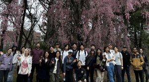 A group of students in front of a flowering cherry tree