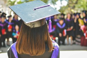 Graduate seen from the back seen with long brown hair and the square scholar cap