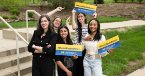 A group pf people holding "mental health matters" signs and smiling