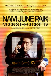 This vertical movie poster for the documentary "Nam June Paik: Moon is the Oldest TV" features a vibrant, retro-analog aesthetic defined by warm yellow and orange tones and heavy horizontal scan lines mimicking an old television screen. The top half displays the title in bold black lettering, accompanied by high-praise quotes from Variety and The Hollywood Reporter and credits for director Amanda Kim and narrator Steven Yeun. Centrally, a vintage CRT television houses a black-and-white portrait of the artist, Nam June Paik, holding a telephone to his ear, while a color-photographed hand reaches in from the right to touch the set. The bottom section is grounded by prestigious film festival laurels from Sundance, MoMA, and CPH:DOX, followed by a standard credit block, all coming together to evoke a sense of nostalgic, technological innovation.